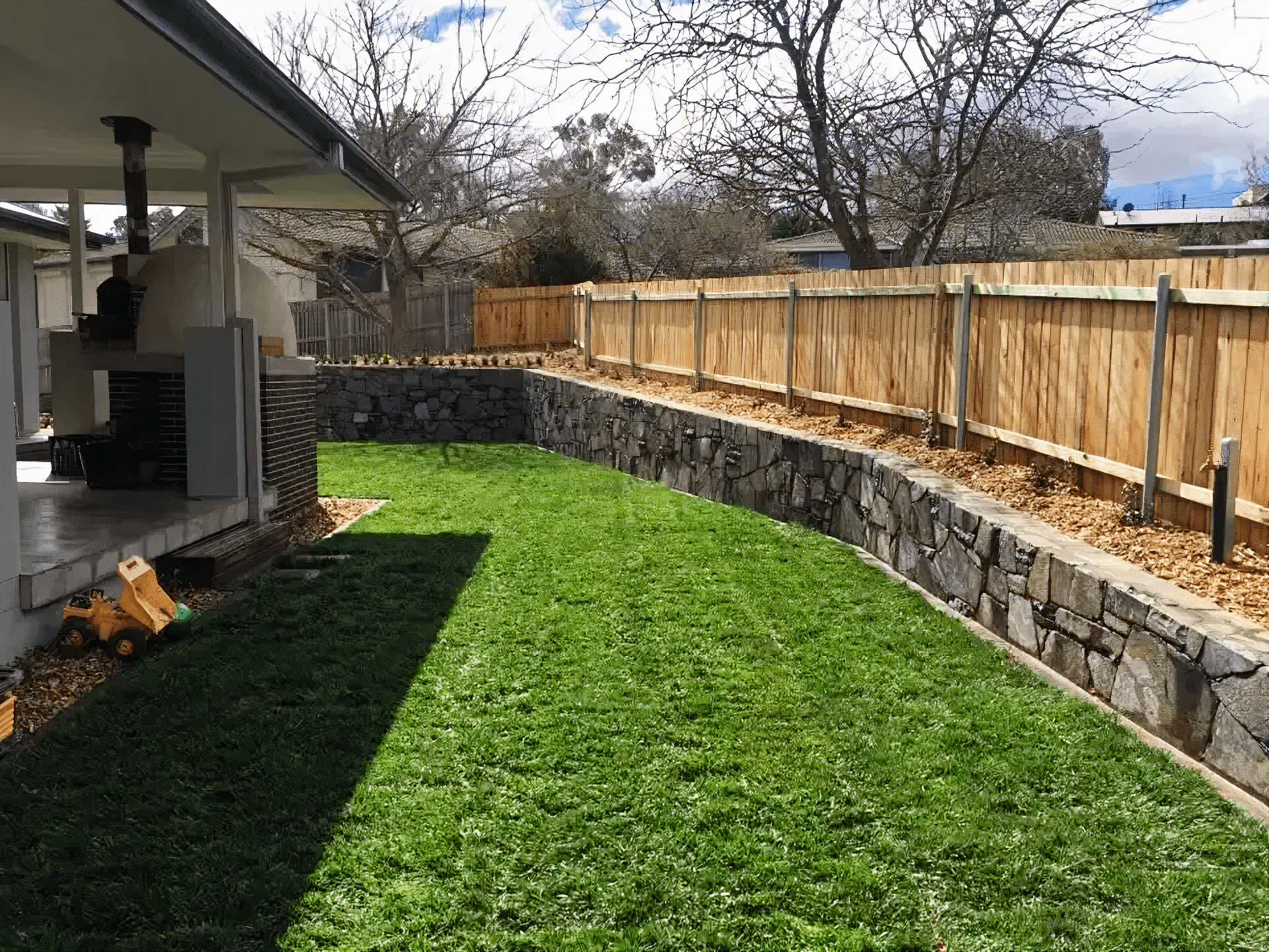 Beautiful stone retaining wall with turfed lawn